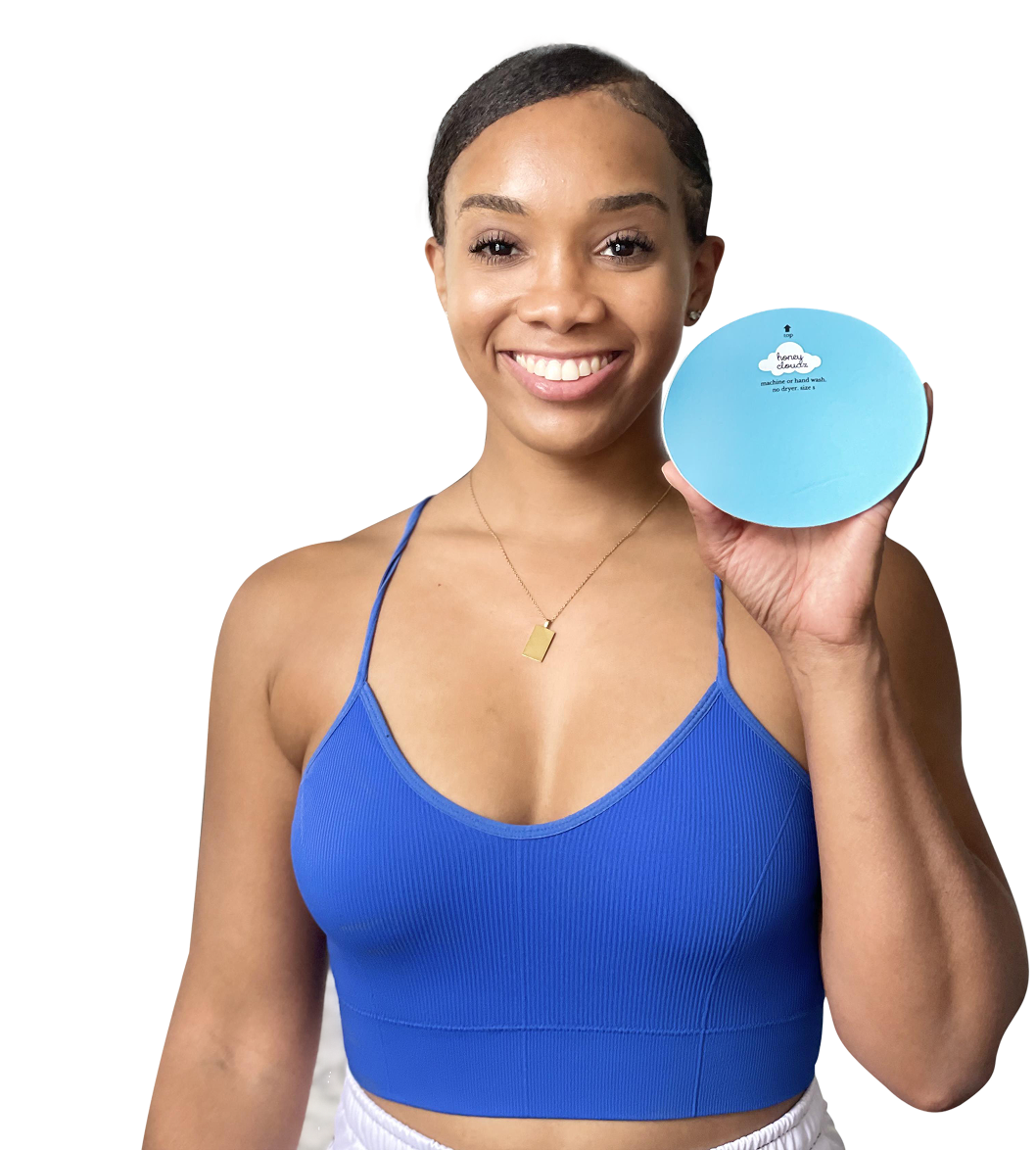 Woman in blue sports bra holding a round product box with bra insert, promoting reusable and washable design
