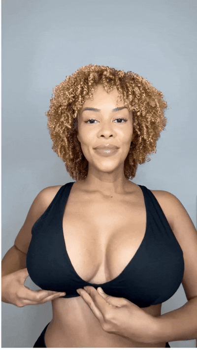 Woman smiling while wearing a black sports bra with Honeycloudz bra pads inserted.