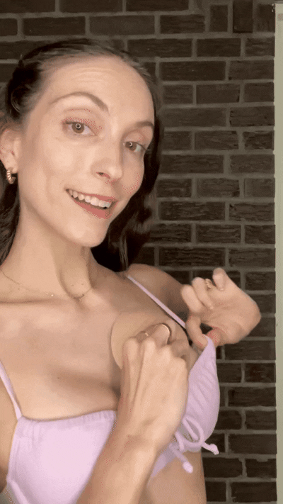 Woman inserting a blue Honeycloudz bra pad into her black sports bra
