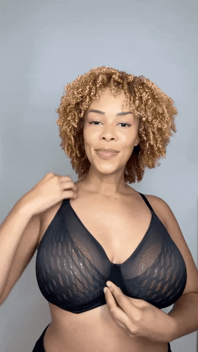 Woman smiling while wearing a black sports bra with Honeycloudz bra pads inserted.