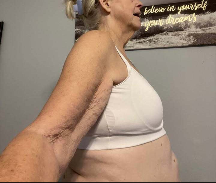 Before adding Honey Cloudz breast forms in a white sports bra.