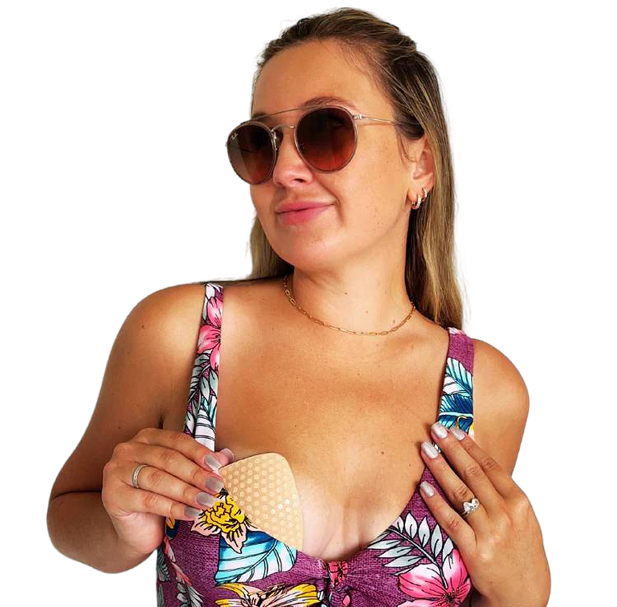 Woman in colorful swimsuit and sunglasses holding a beige bra insert, designed for everyday comfort and support.